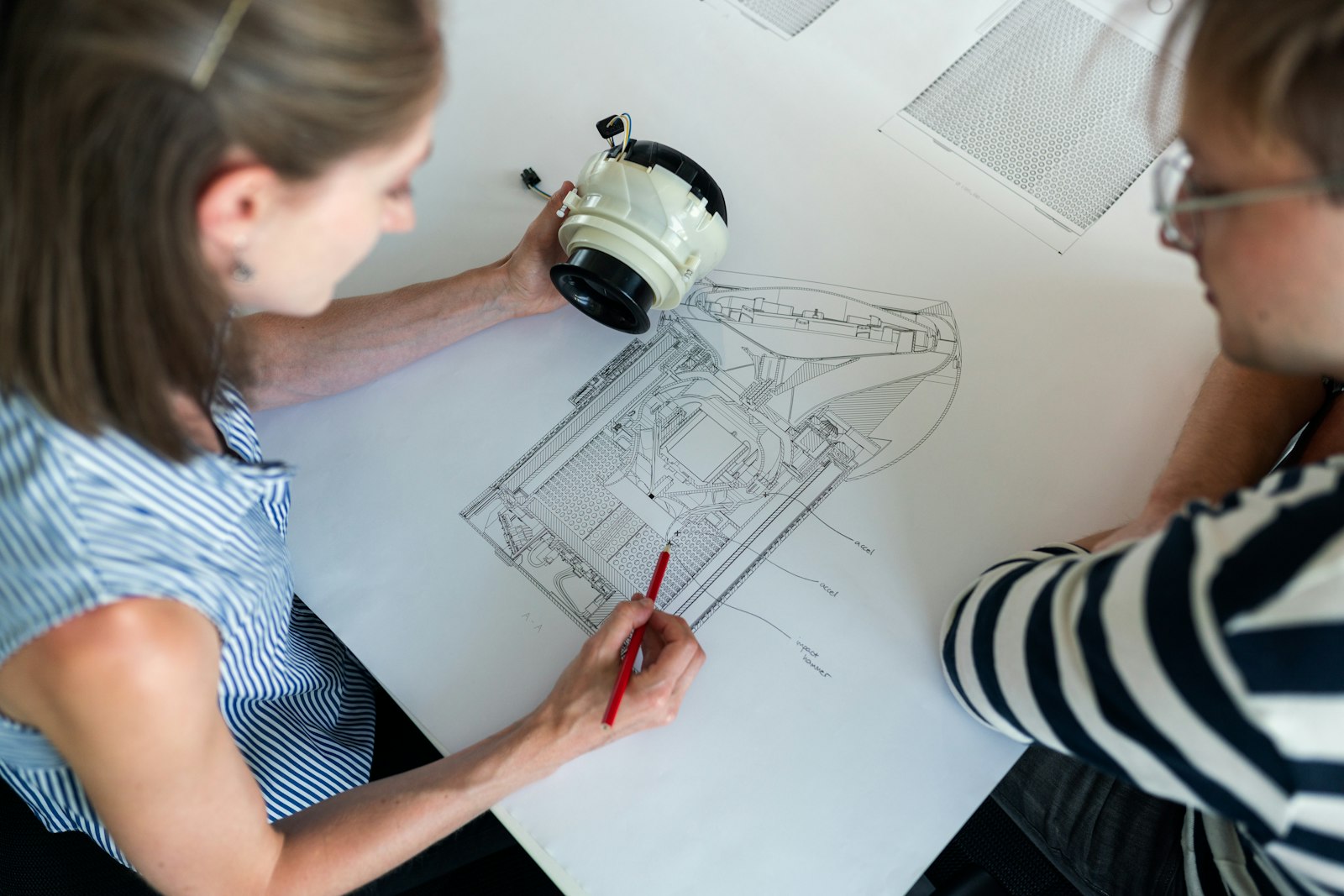 Equipe de engenharia analisando desenho técnico de equipamento